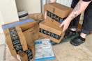 Someone picking up Amazon prime boxes on the porch