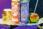 Two orange and purple cans of energy drinks next to a caramel apple and Halloween colors