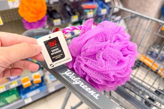 person holding the tag of a purple bath loofah in a cart