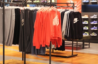 Nike sweatshirts and sweatpants hanging from a rack at the Nike store