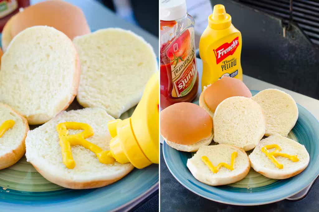 Someone using a mustard bottle to write the letters "W" and "R" on some hamburger buns, and a plate showing the buns next to a bottle ...