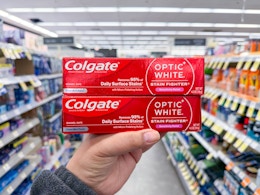 hand holding colgate toothpastes in walgreens