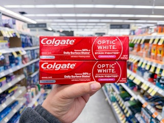 hand holding colgate toothpastes in walgreens