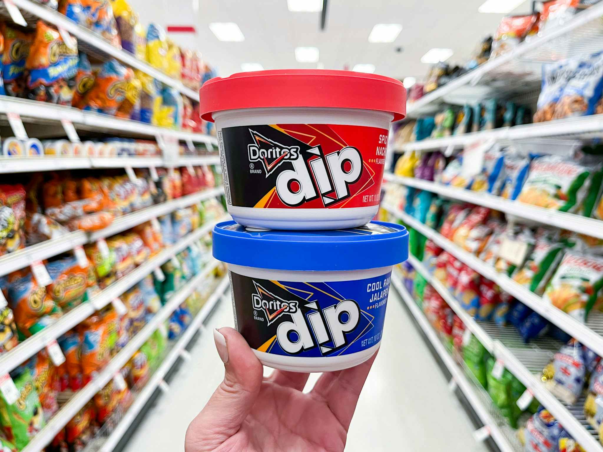 hand holding two doritos dips in target aisle