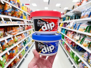 hand holding two doritos dips in target aisle