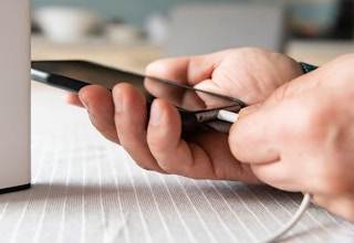 A person plugging in a cord to charge a phone