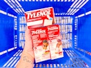 hand holding 3 tylenol products over a walmart basket