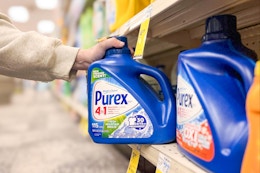 hand grabbing a bottle of purex laundry detergent off the shelf