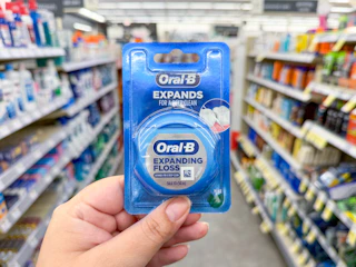 hand holding oral-b floss in walgreens