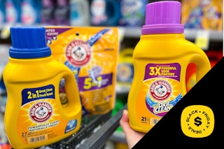hand holding laundry soap next to shopping cart