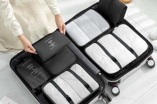 someone packing a suitcase with a Packing Cube Set