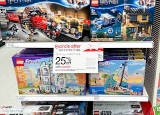 A target circle offer sign for a Target toy sale 25% off coupon on a shelf with LEGO sets