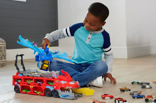 a kid playing with a hot wheels toy