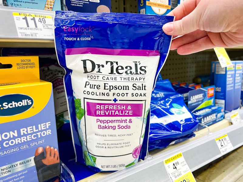 person grabbing a bag of dr teals epsom salts off the shelf