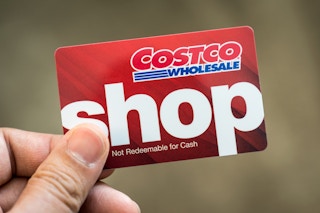 person holding up a costco shop gift card