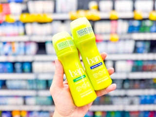 hand holding two ban deodorants in walmart aisle
