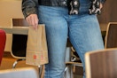 a person holding a mcdonalds bag in a mcdonalds