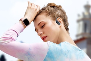 a woman exercising with wireless earbuds on