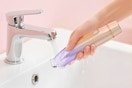 a woman rinsing a bikini trimmer