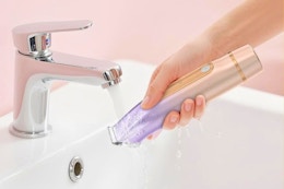 a woman rinsing a bikini trimmer