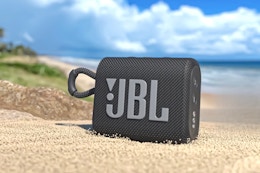 JBL Go3 Speaker (lifestyle image from target.com). Product displayed outdoors in the sand.