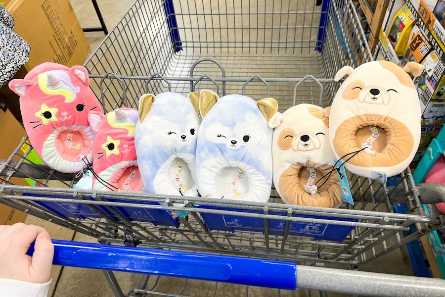 person pushing a cart with 3 pairs of squishmallows slippers in it