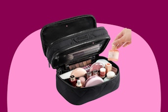 Makeup and toiletry bag in black quilted fabric with two zippered tiers and pockets and elastic within them