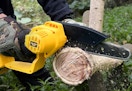 a person using a chainsaw to saw a log
