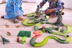 Lifestyle image of the USA Toyz Dinosaur Dash Track being played with by children sitting on the floor