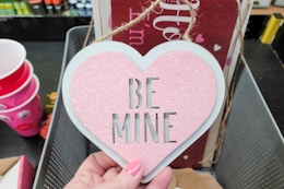 hand touching a valentine's day heart sign
