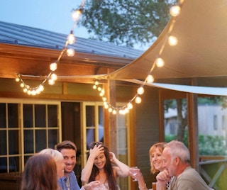 A group sitting outside under string lights.