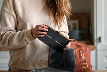a person putting a bento box in a lunchbag