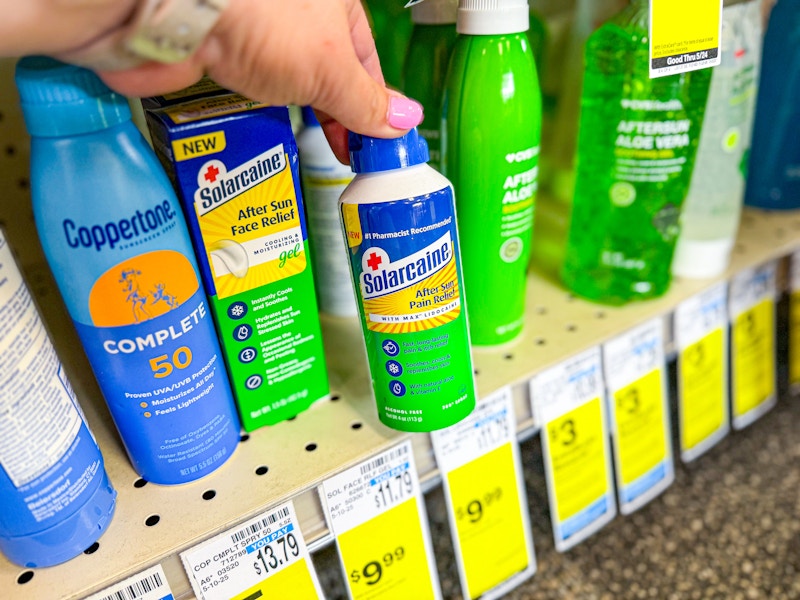 person grabbing a can of solarcaine after sun pain relief off a shelf