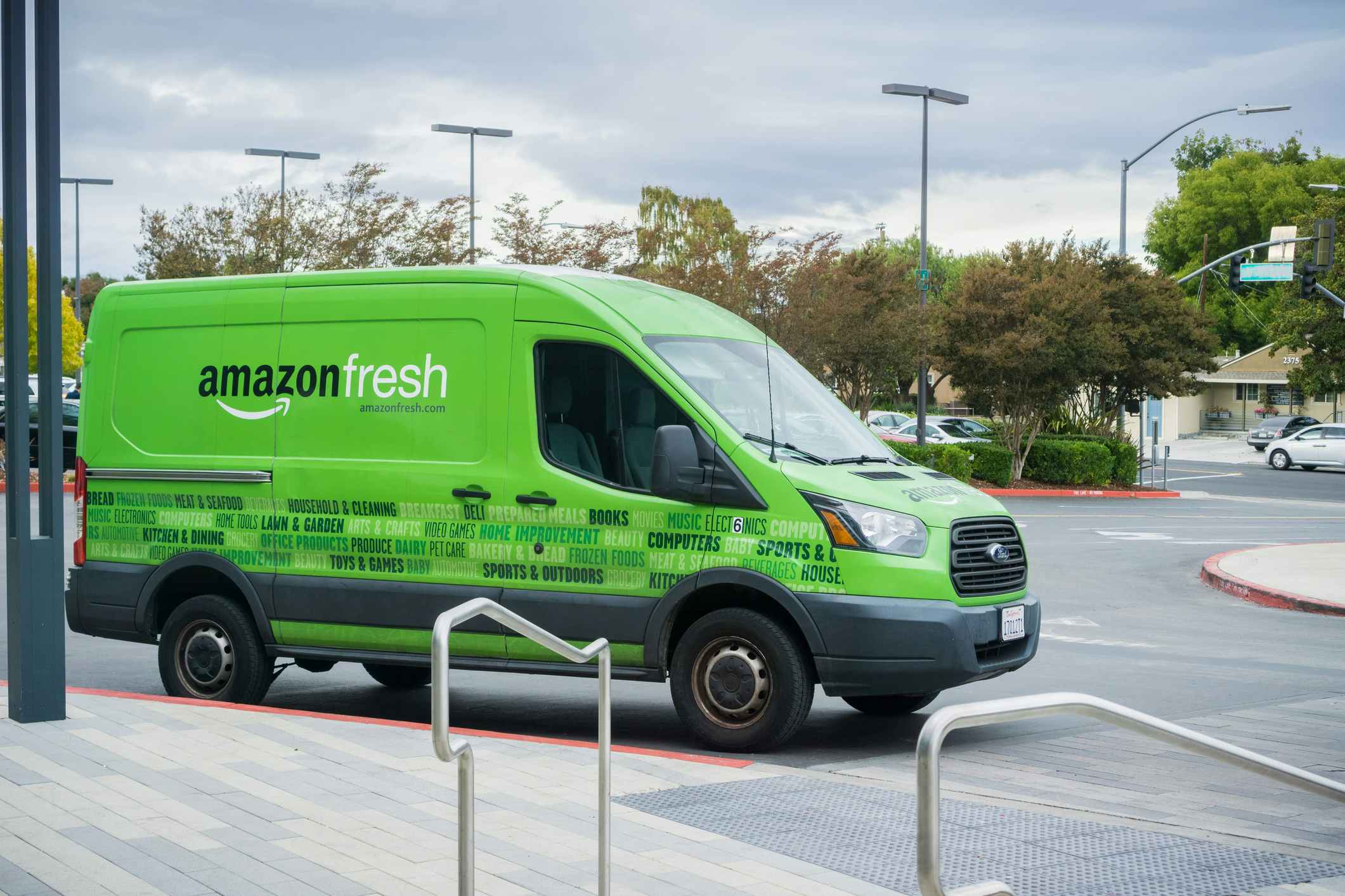 An Amazon fresh van parked by a curb.