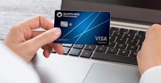 Someone looking at their Chase Sapphire credit card while on their laptop