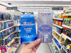 hand holding crest pen and whitening kit in walgreens
