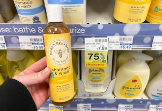A person's hand holding a bottle of Burt's Bees