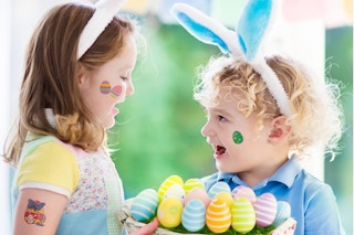 two kids wearing easter egg tattoo stickers holding an easter basket