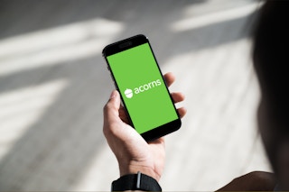 hand holding smartphone with acorns app open