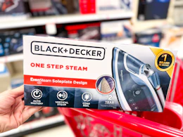 hand holding a black+decker steam iron on a target cart