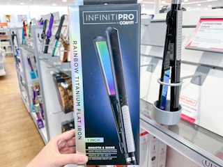 Woman holding Conair flat iron.