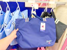 hand grabbing a champion harbor tote bag at target