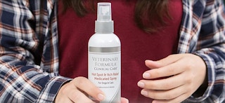 a person holding a pet itch relief spray