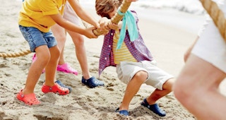 a family wearing crocs playing on a beach