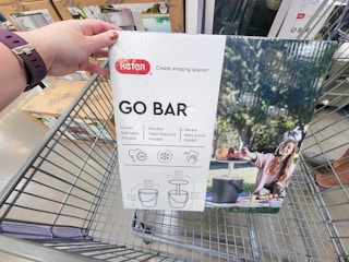 hand holding a keter go bar in a cart