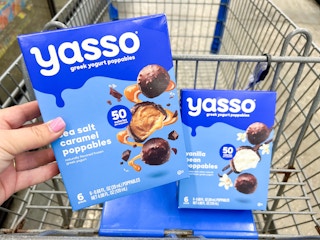 hand holding box of Yasso poppables in front of shopping cart