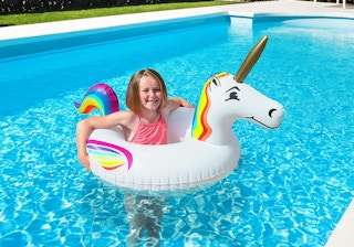 a girl with a unicorn pool float in a pool