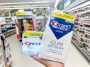 hand holding two crest premium toothpaste packs