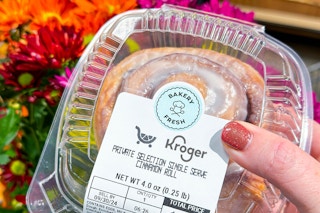 a person holding kroger cinnamon roll 