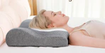 a person laying on a cervical pillow